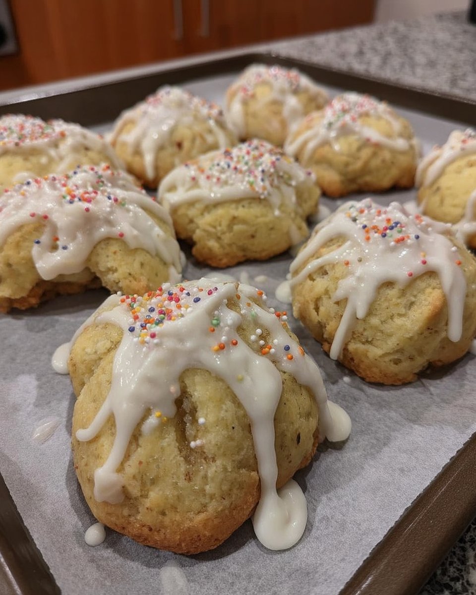 Soft Italian Christmas cookies with white glaze and rainbow sprinkles on a plate