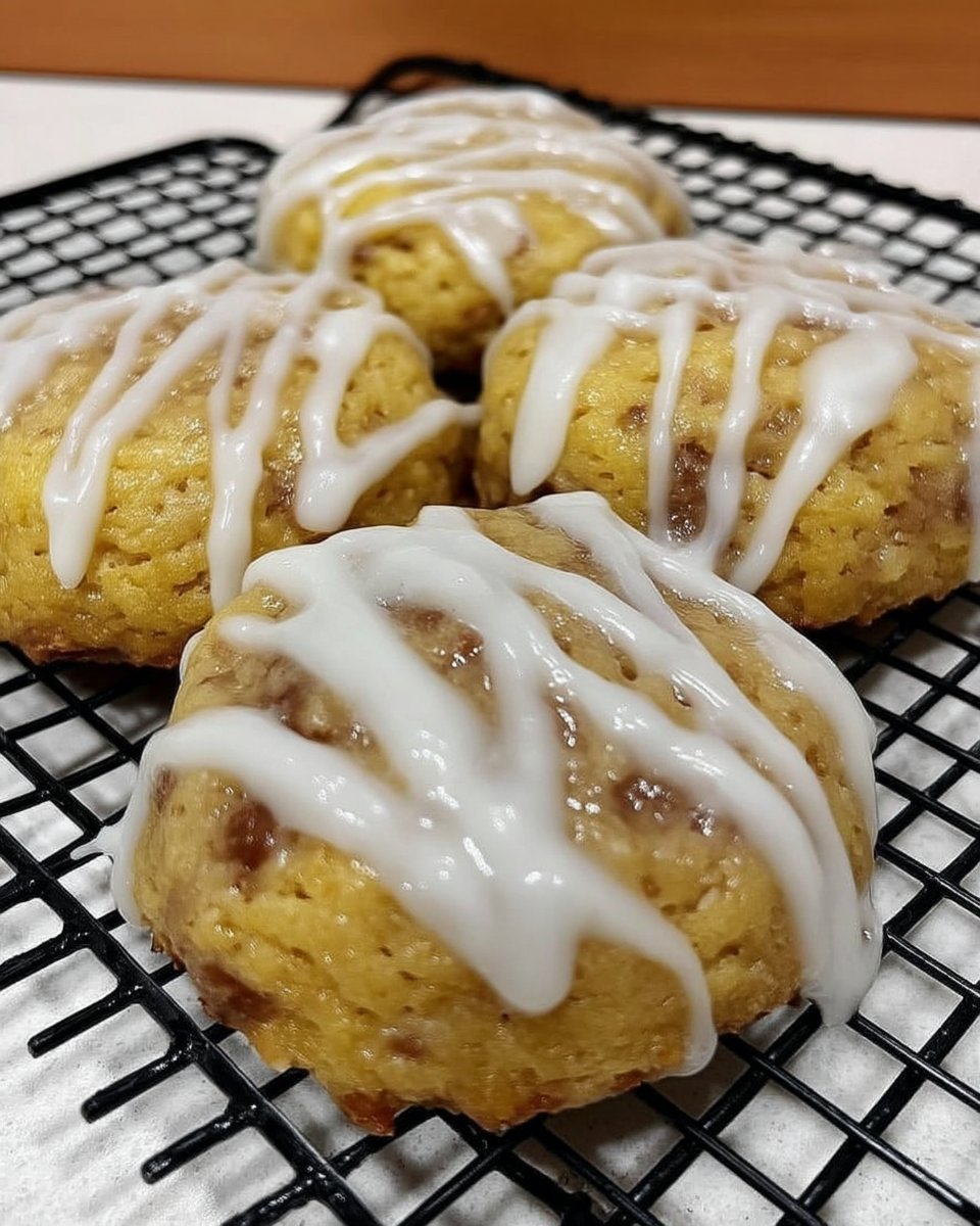 Freshly baked lemon glazed cookies on a parchment lined sheet with a smooth white glaze