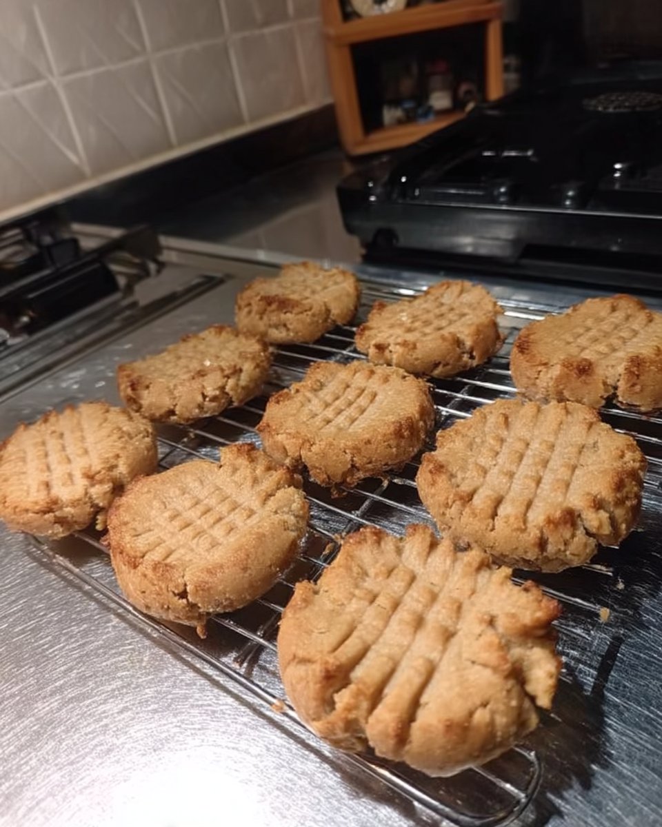 Flourless peanut butter cookies served on a white plate with a steaming cup of tea