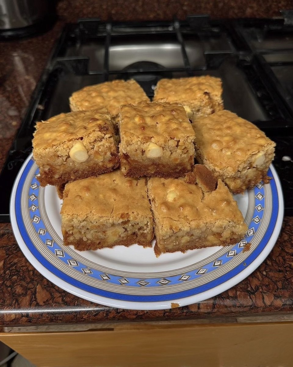 A plate of white chocolate macadamia cookies served with a cup of tea