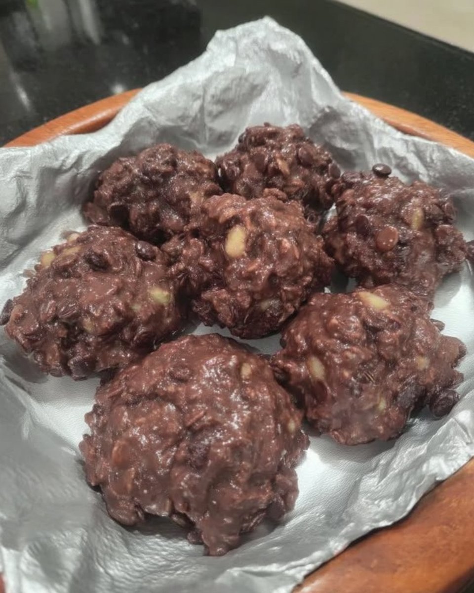 A tray of freshly dropped no bake chocolate oatmeal cookies on waxed paper