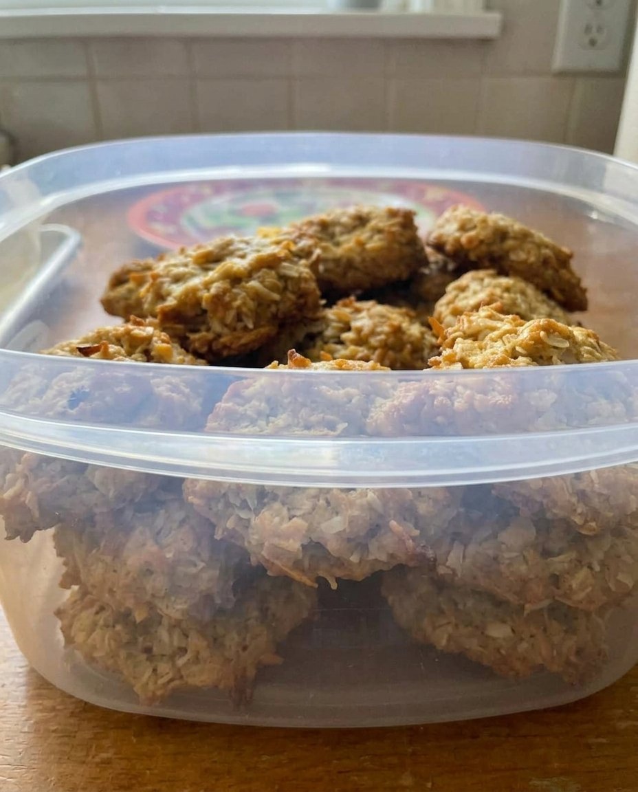 A stack of golden oatmeal coconut cookies on a rustic wooden table