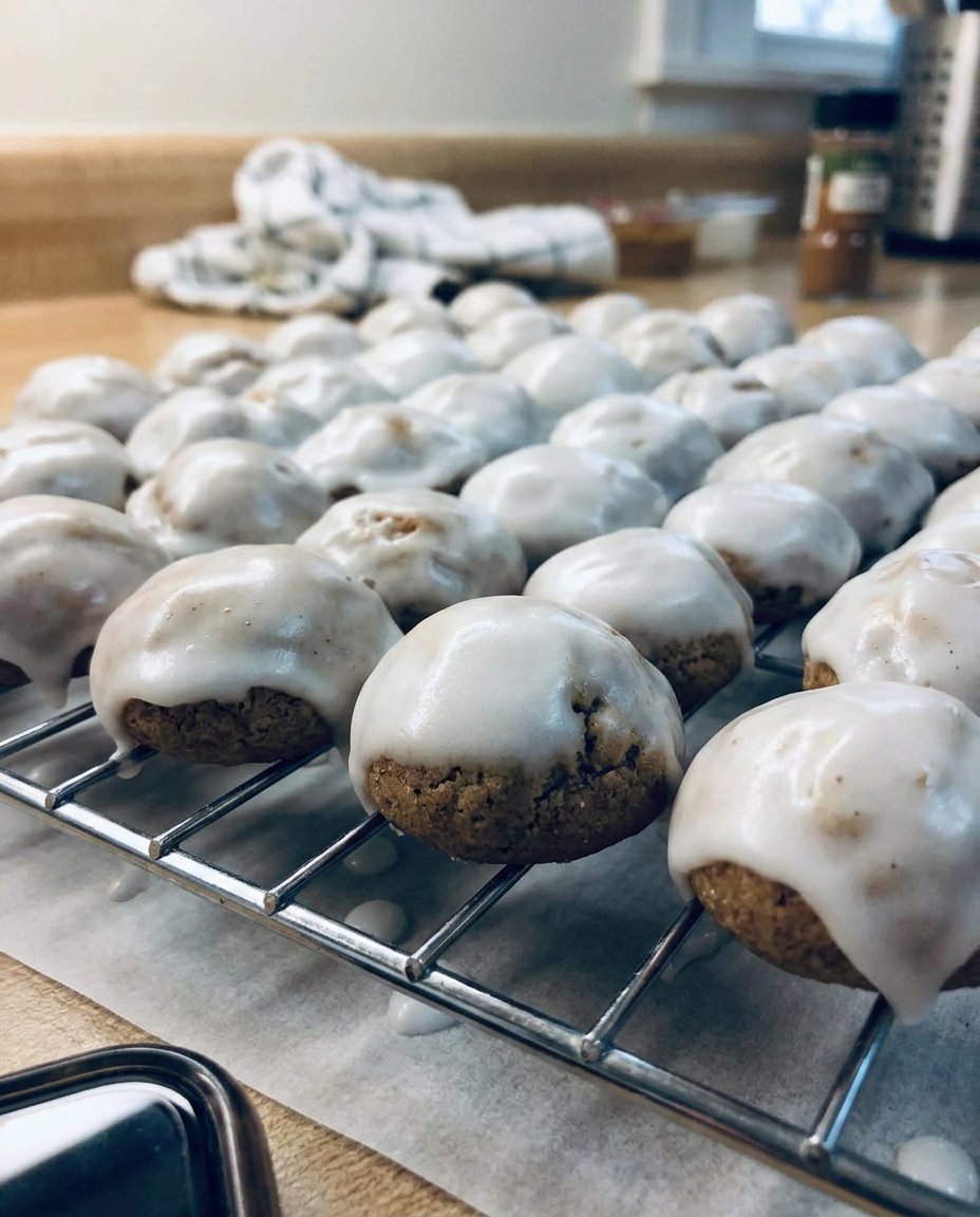 A pile of glazed pfeffernusse 2 spice cookies on a rustic wooden table