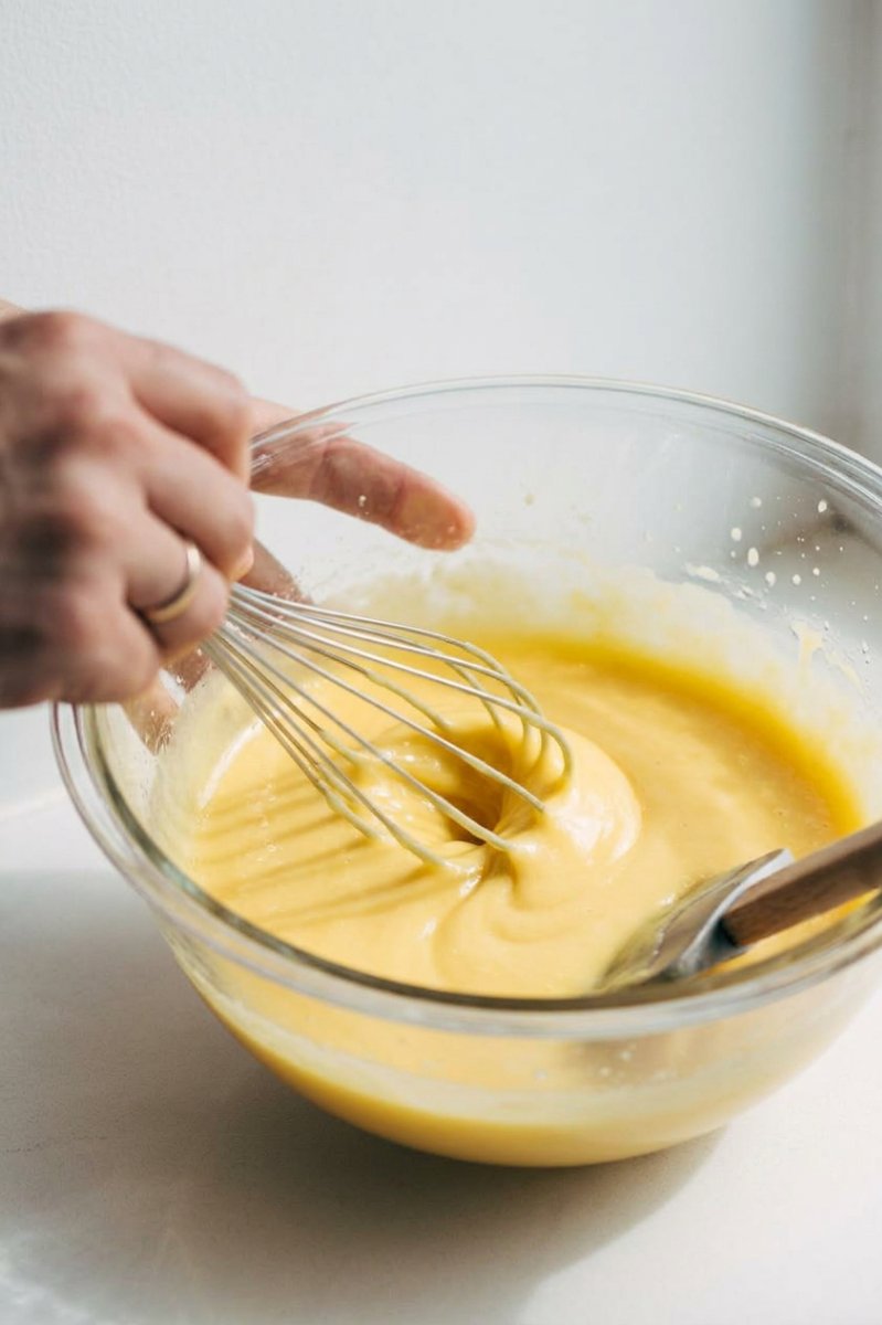 Bowls of flour, vegetable shortening, sugar, and eggs arranged on a white marble surface.