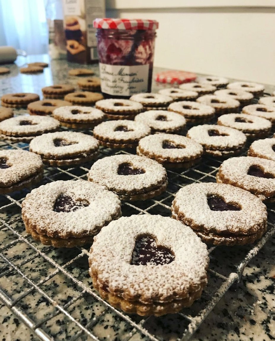 Heart shaped raspberry linzer cookies dusted with powdered sugar