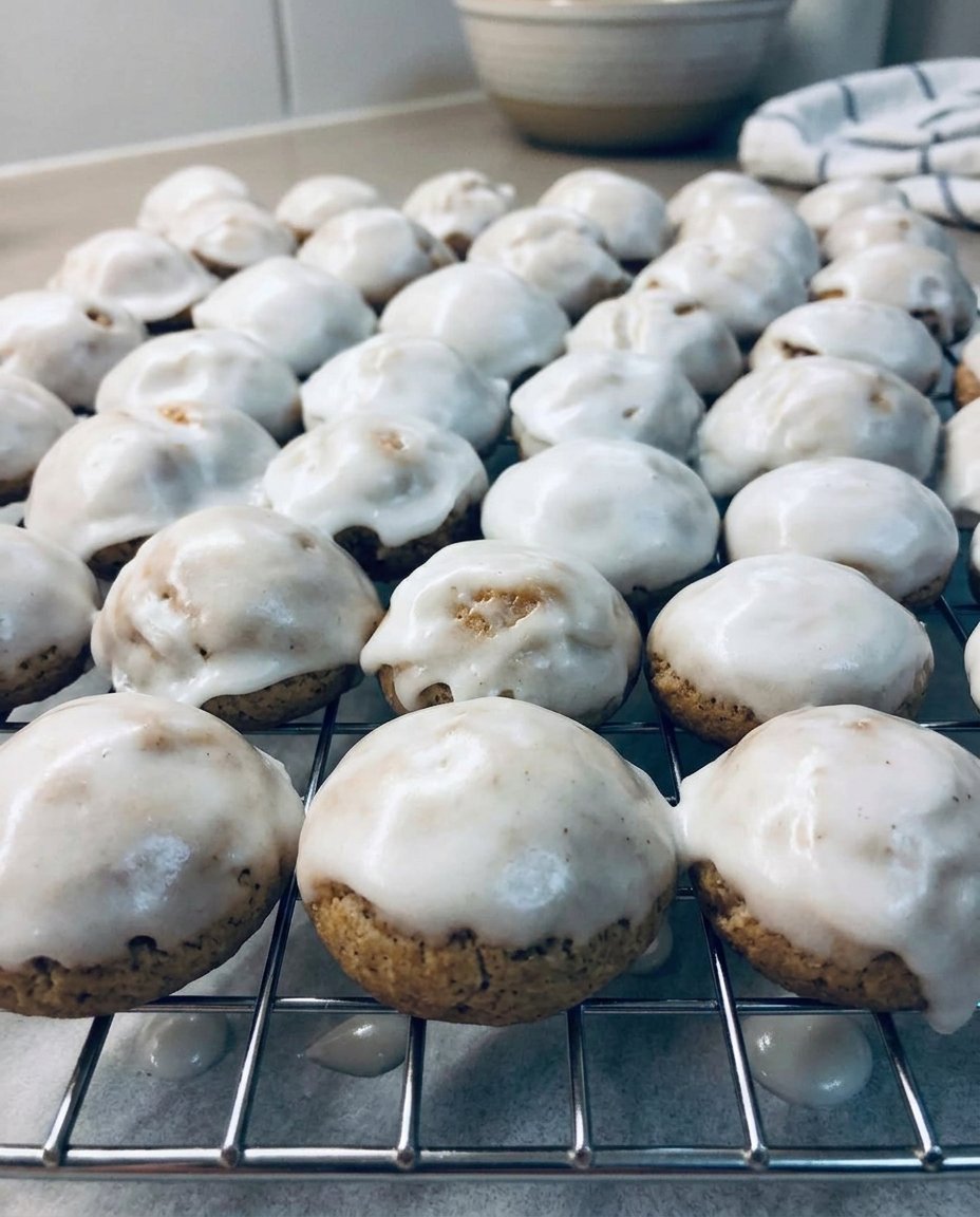 Glazed spice cookies served with a cup of hot tea and cinnamon sticks
