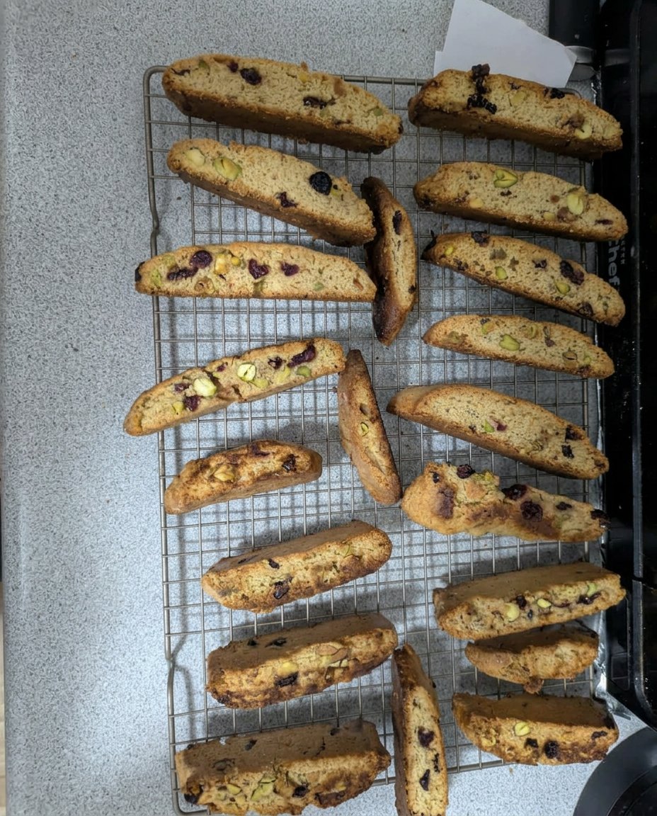 Fresh cranberry and pistachio biscotti on a cooling rack showing the interior crumb