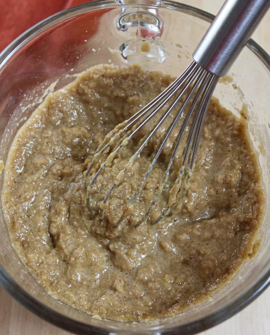 Hands rolling gingersnap dough into balls and coating in cinnamon sugar