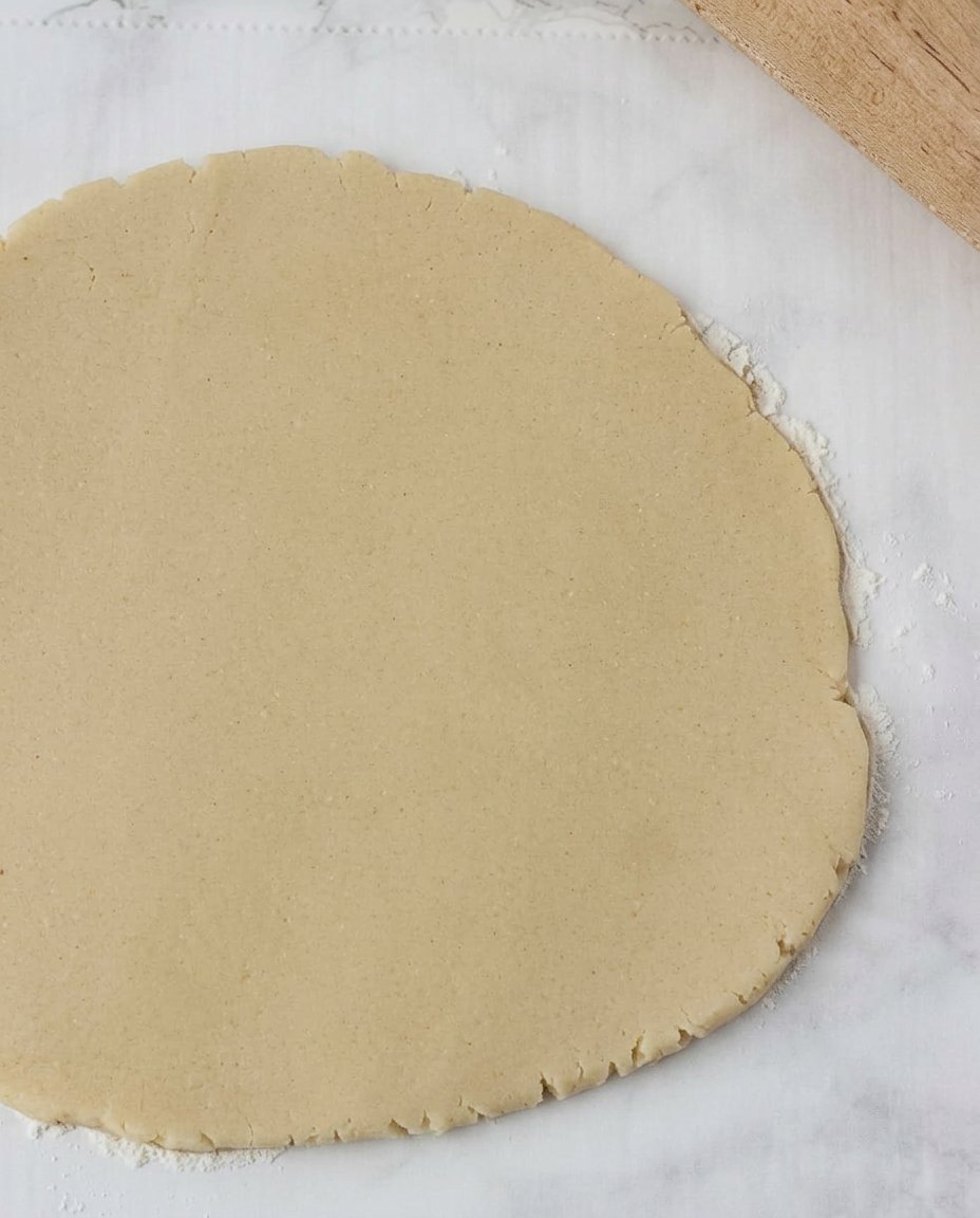 Rolling out vegan sugar cookie dough on parchment paper