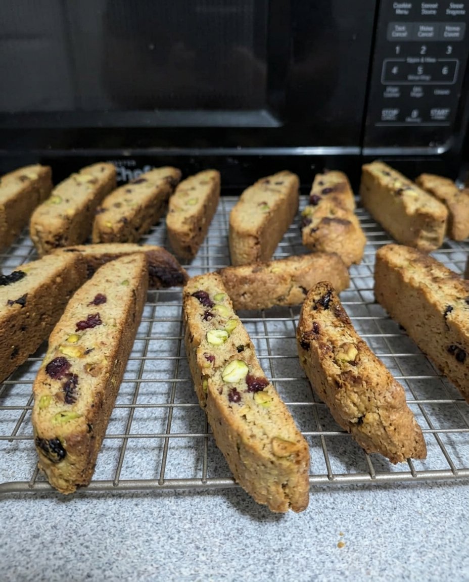 Cranberry pistachio biscotti being dipped into a cup of espresso